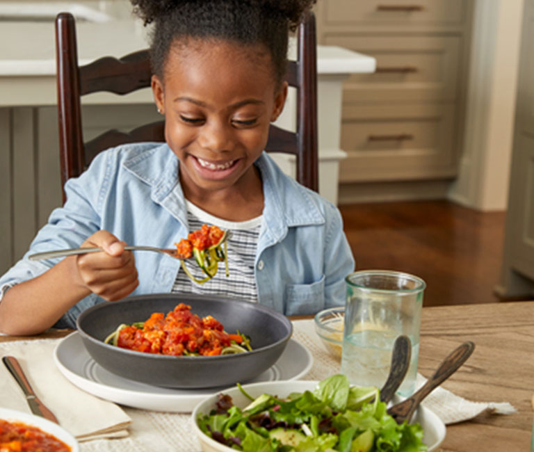 Little girl eating at dinner table